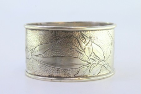 Argola de guardanapo em prata martelada com motivos florais gravados envolvendo cartela para monograma.